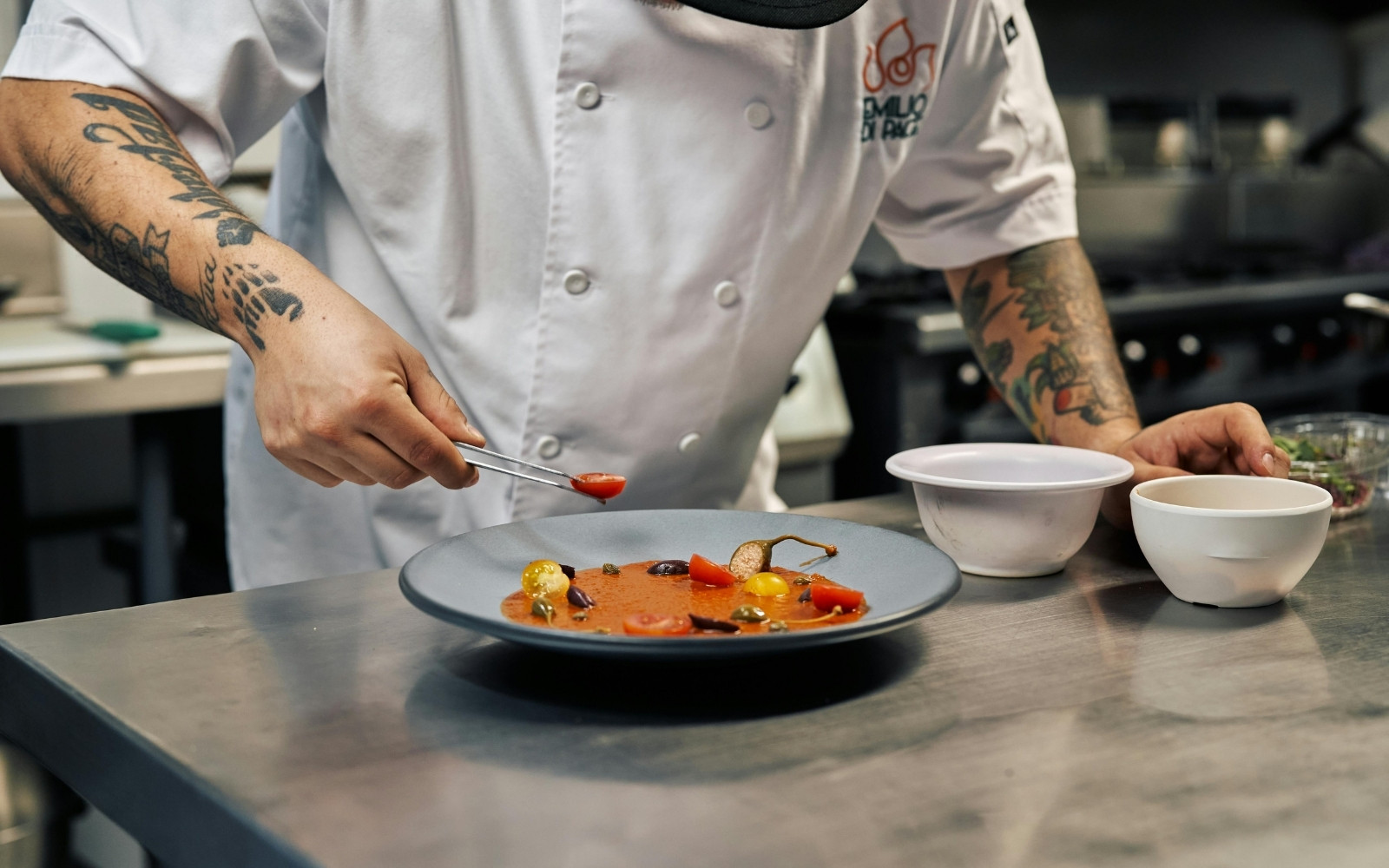 chef guarnisce un piatto nell'area di impiattamento della cucina di un ristorante